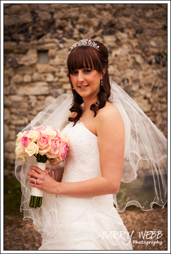 Bride posing with bouquet at Castle Cooling Barn in Kent - Wedding Photography